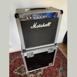 Kytarový kombozesilovač v bílém vinylovém potahu s černou textilní maskou a nápisem Marshall. Horní ovládací panel je z chromovaného kovu s červeným…