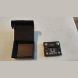 Černý kytarový předzesilovač s nápisy JOYO a PREAMP HOUSE. Na horní straně jsou čtyři otočné ovladače, přepínač a několik textových popisků včetně BA…