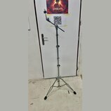 Stříbrný kovový mikrofonní stojan s trojnožkou a teleskopickým stoupacím mechanismem. Horní část obsahuje kloubový ramene s držákem na mikrofon. Na s…