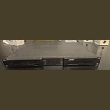 Černý rackový zesilovač s kovovým povrchem. Na předním panelu je vlevo nápis PSX1204D, uprostřed kontrolní panel s LED indikátory a vpravo logo BOSE…