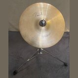 Zlatý kovový činel typu splash na černém stativu. Na povrchu je nápis "Paiste" a v dolní části označení "Splash 10"". Povrch činelu vykazuje jemné ko…