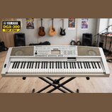 Stříbrošedý digitální klavír značky YAMAHA umístěný na černém X-stojanu. Na horním panelu je uprostřed logo YAMAHA a vpravo nápis graded Zram. Nástro…