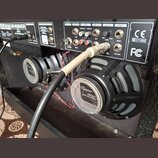Zadní panel černého kytarového komba značky BEHRINGER s viditelnými konektory, ovládacím prvkem LEVEL a nápisy jako LINE OUT, AUX IN či INSERT. V pra…