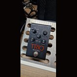 Černý efekt pedál s nápisem TRIO Band Creator. Zařízení obsahuje několik ovládacích prvků: otočný přepínač GENRE s označením ALT ROCK, ROCK, COUNTRY,…