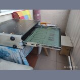 Stříbrný kovový rack s vysunutým šuplíkem. Vnitřek šuplíku je vyložen zelenou deskou s vyfrézovanými drážkami a otvory. Povrch horní desky racku je č…