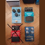 Fotografie zobrazuje čtyři efektové pedály v různých barvách. V horní řadě je světle modrý pedal s nápisy tc electronic a SKYSURFER REVERB a tyrkysov…