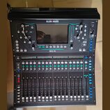 Černý digitální mixážní pult značky ALLEN&HEATH, model SQ-5. Zařízení má v horní části displej a ovládací prvky s modrým podsvícením, ve spodní části…