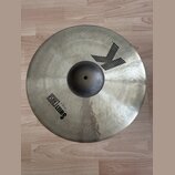 Kovový činel v matné stříbrno-zlaté barvě s viditelnou strukturou povrchu. Na povrchu je černý nápis SWEET CRASH a menší text 19" / 48 cm. V horní čá…