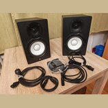 Dva černé studiové monitory s bílými membránami basových reproduktorů a černými výškami. Na spodní části obou reproduktorů je bílé logo Yamaha. K nim…