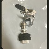 Fotografie zobrazuje dvě chromované kovové součástky, pravděpodobně části mechanismu pro ladění nebo upevnění nástroje. Horní díl obsahuje černou pla…