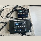 Černý efektový procesor Boss GT-1000CORE s digitálním displejem a několika ovládacími knoflíky. Na zařízení je vidět nápis BOSS GT-1000CORE GUITAR EF…
