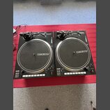 Dvě černé turntable gramofony s logem @reloop na talířích. V levém dolním rohu obou přístrojů je nápis serato. Povrchy jsou v dobrém stavu, bez vidit…