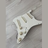 Bílý pickguard pro elektrickou kytaru s třemi krémovými snímači typu single-coil. Na krytkách snímačů je nápis "Nocdanima". Součástí jsou tři bílé ov…
