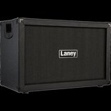 Černý kytarový kombozesilovač nebo box s texturovaným povrchem a látkovou maskou. Uprostřed masky je bílo-černý obdélníkový štítek s nápisem Laney. N…
