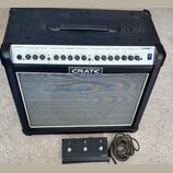 Černý kytarový kombozesilovač s bílým lemováním mřížky reproduktoru. Na horním ovládacím panelu jsou nápisy CRATE, HIGH GAIN, OVERDRIVE, CLEAN, EFFEC…