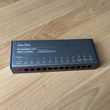 Černý napájecí adaptér s nápisy Harley Benton, PowerPlant ISO-12 Pro a ISOLATED OUTPUT POWER SUPPLY. Zařízení má v horní části řadu modrých kontrolní…