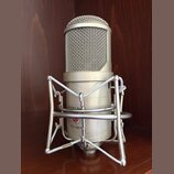 Stříbrný kondenzátorový mikrofon v pavoucím držáku. Na těle mikrofonu jsou nápisy LAUTEN AUDIO a FC-357. Povrch je v dobrém stavu bez viditelného opo…