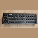 Černý analogový syntetizátor s nápisem PRO-1 a logem behringer. Přední panel obsahuje množství černých otočných ovladačů, přepínačů a zapojovacích ko…