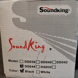 Fotografie znázorňuje část bílého kartónového obalu. V horní části je černý nápis Soundking® a uprostřed červený nápis SoundKing. Dole jsou uvedeny m…