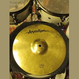 Zlatý cymbál typu splash položený na černém texturovaném podkladu. V horní části je černé logo „Anatolian“. Dole je nápis „Ultimate 12"/30cm Splash“.…