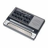 Černý přenosný syntetizátor s bílým nápisem Stylophone TM GEN X-1. Horní panel obsahuje řadu ovládacích knoflíků s popisky jako ATTACK, PITCH, DECAY,…