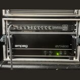 V hliníkovém racku jsou umístěna dvě černá zařízení značky Ampeg. Horní jednotka nese nápis SVPCL ALL TUBE BASS PREAMP a má řadu ovládacích knoflíků…