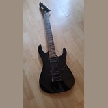 Černá elektrická kytara s tmavým hnedým hmatníkem a dvěma humbuckery. Na hmatníku je viditelný bílý štítek s nápisem "No 107". Na hlavě krku je bílé…