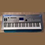 Stříbrný digitální klavír s bílými a černými klávesami. Na horní části je vlevo logo YAMAHA s doprovodným symbolem, vpravo nápis MM6 a vlevo nad kláv…