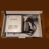 Stříbrný efektový pedál s nápisy KETRON, SD2 a ORCHESTRAL WIZARD. Na horní hraně jsou označení vstupů: POWER DC 12V, L OUT, R OUT, IN MIDI a THRU MID…