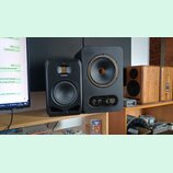 Na fotce jsou tři studiové monitory. Nejlevý vlevo je černý s nápisem ADAM AUDIO, prostřední je větší černý reproduktor s nápisy GOLD A a TAMPET v do…