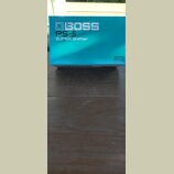 Modrá krabice s bílými nápisy. Na přední straně je logo BOSS a text PS-5 SUPER Shifter. V pravém dolním rohu je malý bílý štítek s nápisem USE BOSS P…