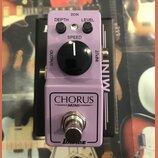 Fialový efekt pedál s nápisy CHORUS MINI a logem Ibanez. Na horní části jsou dva malé černé oválné knoflíky s popisky DEPTH a LEVEL, jeden velký čern…