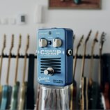 Modrý efekt pedál s kovovým povrchem. Na přední straně jsou nápisy MULTICOMP, True Dual Band Compressor, Guitar edition a Made by EBS Sweden AB. Pedá…