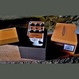 Kompaktní kytarový zesilovač v béžovém provedení s kovovým rámem. Na přední straně je nápis WOODROW 55 Instrument Amplifier a logo UA v kosočtverci.…