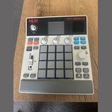 Bílo-šedý sampler MPC SAMPLE značky AKAI professional. Zařízení obsahuje 16 šedých samplingových padů, několik ovládacích knoflíků a řadu tlačítek s…
