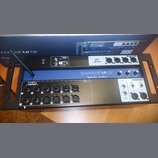 Černý digitální mixážní pult v rackovém provedení s modrým pruhem uprostřed. Na přístroji jsou nápisy Soundcraft Ui 16, lexicon, dbx a DiGiTech. Zaří…