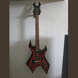 Černá elektrická kytara s ostře hranatým korpusem a hlavou. Na černém povrchu těla jsou červené plameny a na hlavě je bílé logo B.C. Rich. Nástroj má…