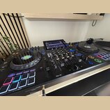 Černý DJ 컨트롤러 s integrovaným displejem a dvěma jog-koly. Na levém jog-kole je viditelné logo GRUCAST a na spodní části přístroje nápis XDJ-AZ. Zaříze…