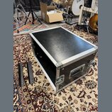 Černý transportní flightcase s hliníkovými hranami a rohy. Na přední straně je umístěna jedna černá plastová rukojeť a dva kovové zámky. Vedle kufru…