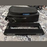 Černý kovový pedalboard s dvěma vodorovnými nosnými lištami. Na spodní hraně je bílý nápis pedaltrain® U.S. Pat. No. 7,439,023 a označení nano. Vedle…