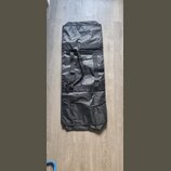 Černý obdélníkový obal z syntetického materiálu s jemným leskem. V horní části jsou dvě černé popruhy s plastovými přezkami a šitými úchyty. Povrch m…