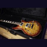 Polodupatá elektrická kytara s výraznou žlutě-hnědou strukturou dřeva na topu a tmavě hnědým okrajem. Nástroj má dva humbuckery, stoper a čtyři ovlád…