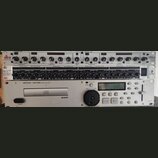 Fotografie zachycuje tři rackové zařízení naskládaná nad sebou. Horní přístroj je kompresor/limiter značky dbx, model 166xs. Prostřední zařízení je M…