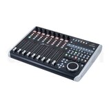 Černý kontrolní povrch s osmi posuvníky a řadou tlačítek. Na horní části je nápis UNIVERSAL CONTROL SURFACE a v pravém horním rohu logo a značka behr…