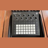 Černý sekvenční syntetizátor Novation Circuit Tracks v černém přepravním pouzdře. Na horní části je nápis CIRCUIT TRACKS a logo výrobce, dále osm oto…