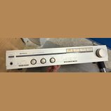 Stříbrný stereo zesilovač značky HITACHI, model STEREO AMPLIFIER HA-3700. Na předním panelu jsou umístěny čtyři otočné ovladače, několik tlačítek a p…