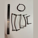 Fotografie zobrazuje pět hnědých patch kabelů s kovovými konektory a jeden samostatný hnědý kroužek z gumy nebo plastu. Vedle kabelů je položeno kovo…