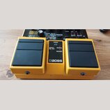 Žlutý kytarový efekt s dvěma černými spínači a centrálním panelem. Na panelu je nápis BOSS, kontrolky POWER, EFFECT ON/OFF a přepínač MANUAL / MEMORY…