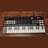 Červený analogový syntetizátor s klaviaturou a ovládacími prvky v horní části. Na pravém horním rohu je logo a nápis SYNTH PRO, vlevo nápisy PARAPHON…