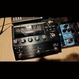 Černý kytarový procesor s kovovým povrchem a nápisem BOSS GT-1000CORE GUITAR EFFECTS PROCESSOR. Zařízení má displej, pět ovládacích knoflíků s čísly…